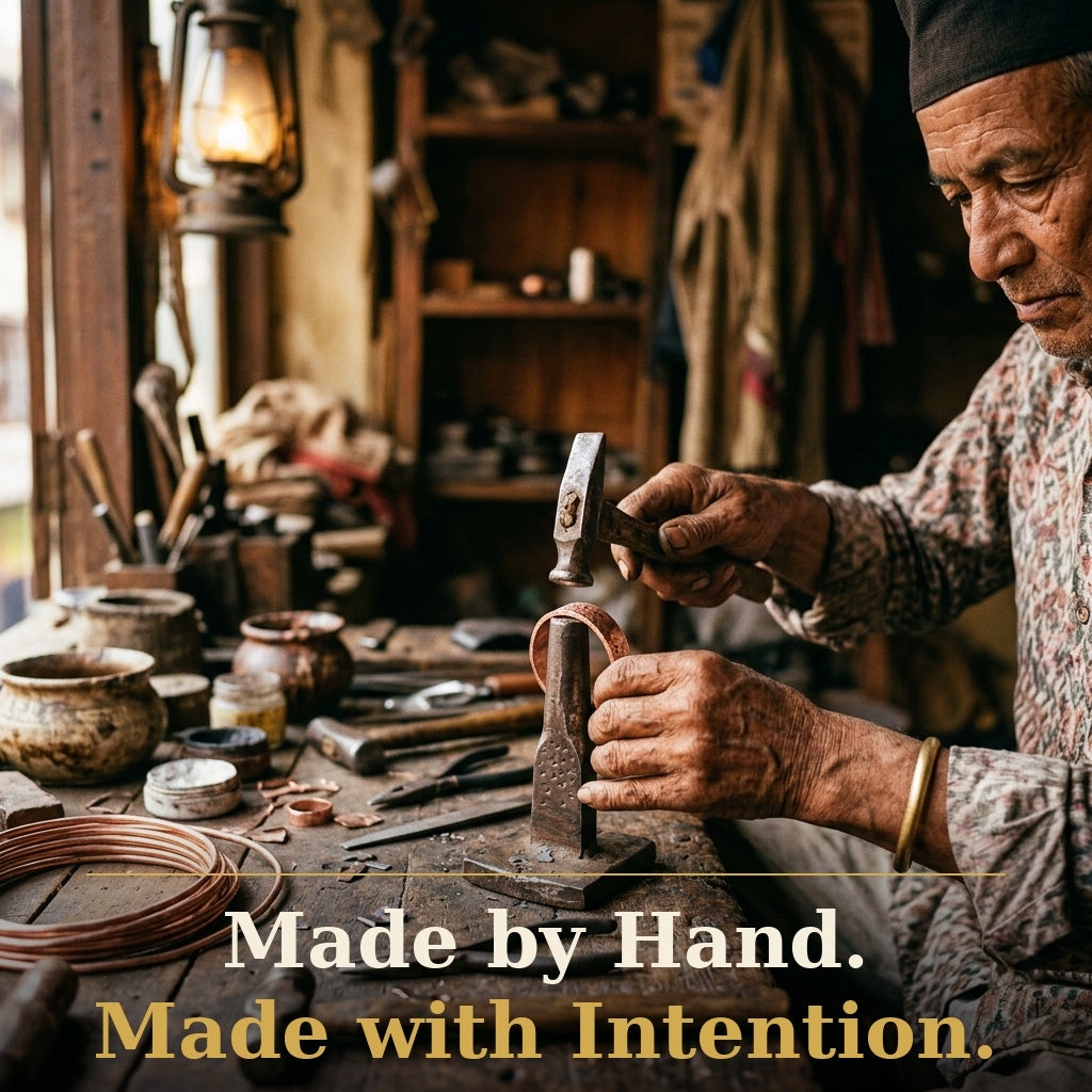 Handmade copper bracelet being shaped by a skilled Nepalese artisan using traditional tools in a rustic workshop
