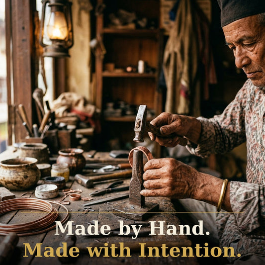Handmade copper bracelet being shaped by a skilled Nepalese artisan using traditional tools in a rustic workshop